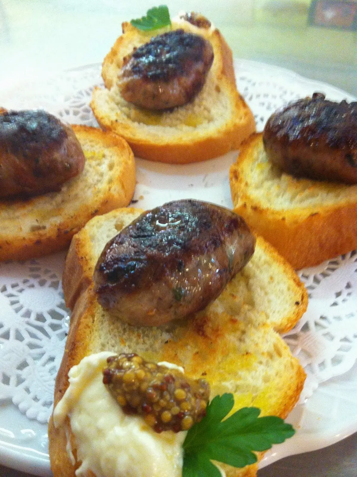 Tostas de pan con figatell a la plancha sobre blonda de papel